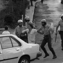 Argazkian, Peio Alkantarilla auzotarra atxilotua eramaten.
1982ko martxoaren 15ean Esteban Muruetagoiena Oiartzungo medikua atxilotu zuten. Egun batzuk geroago, martxoaren 25ean, aske utzi zuten eta torturatu egin zutela salatu zuen. Hiru egun geroago hil zen.
Muruetagoienaren heriotzak protesta ugari piztu zituen. Egian ere manifestazioak izan ziren, autoak gurutzatu ziren, etab.
Protesta horietan, Pedro Alkantarilla auzoko bizilaguna atxilotu zuten.