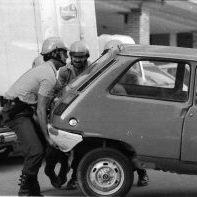 Argazkian, Polizi Nazkonala barrikada bezala gurutzatutako kotxeak mugitzen.
1982ko martxoaren 15ean Esteban Muruetagoiena Oiartzungo medikua atxilotu zuten. Egun batzuk geroago, martxoaren 25ean, aske utzi zuten eta torturatu egin zutela salatu zuen. Hiru egun geroago hil zen.
Muruetagoienaren heriotzak protesta ugari piztu zituen. Egian ere manifestazioak izan ziren, autoak gurutzatu ziren, etab. Protesta horietan, Pedro Alkantarilla auzoko bizilaguna atxilotu zuten.