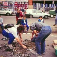 Irudian lurra zulatzen kulunpioak jarri ahal izateko.
Udalak, Lizarribar lantegia (Fabria de gomas) bota ondoren, aparkalekua jarri zuen Plaza Handin. Bizilagunen koordinakundeak eskatzen zuen, egitasmoa definitiboa egiten zen bitartean, espazio libre uztea umeentzako, jolasteko. Honen harira, jai aldarrikatzaile bat antolatu zen. Plazari izena jarri zitzaion eta kolunpioak jarri ziren.