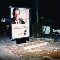 Argazkian, Plaza Berriko sarreran, hauteskundeetarako jarritako panela.
1990eko urrian hauteskunde autonomikoak egin ziren Euskal Autonomia Erkidegoan. Haiei aurkeztu zitzaien EA alderdi gisa, EAJren zatiketaren ondoren, 1986an.
Propaganda sistema berri bat estreinatu zen. Plaza Berrin iragarki handi bat jarri zuten, Carlos  Garaikoetxearen irudiarekin. Herritar askori iruditu zitzaien ezin zela plaza publiko batean sarreran jarri, eta hauteskunde-kartela hautsi zuten. Ez zen Garaikoetxearen alderdiaren aurkako ekintza izan, propaganda sistemaren aurkakoa baizik. Iragarkia jarri zuen enpresak ez zuen berriro jarri.